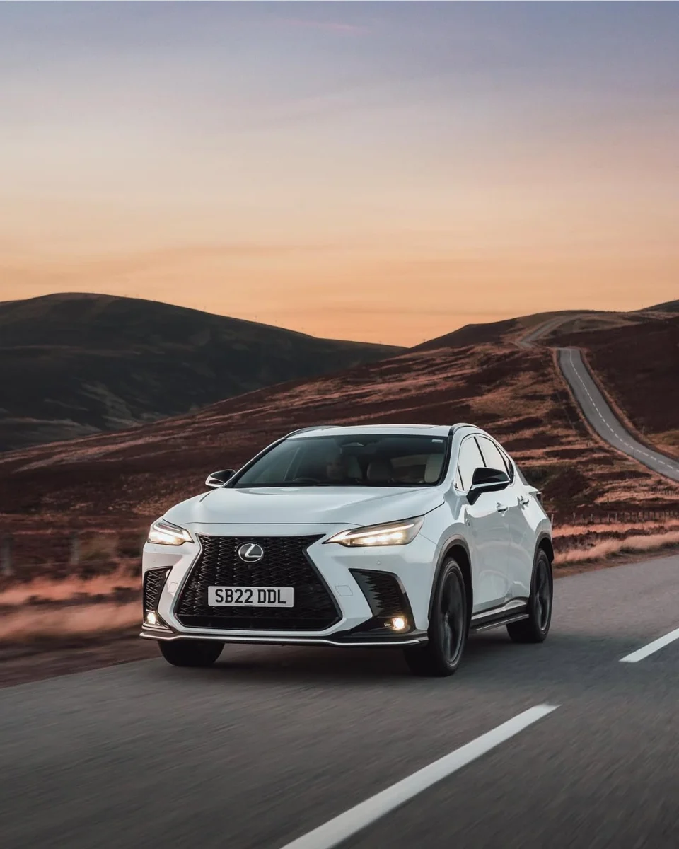 White Lexus on a winding Cairngorms road at sunset