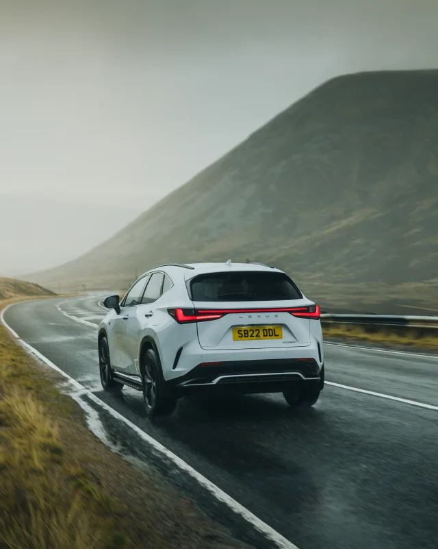 White Lexus driving along a mountain road